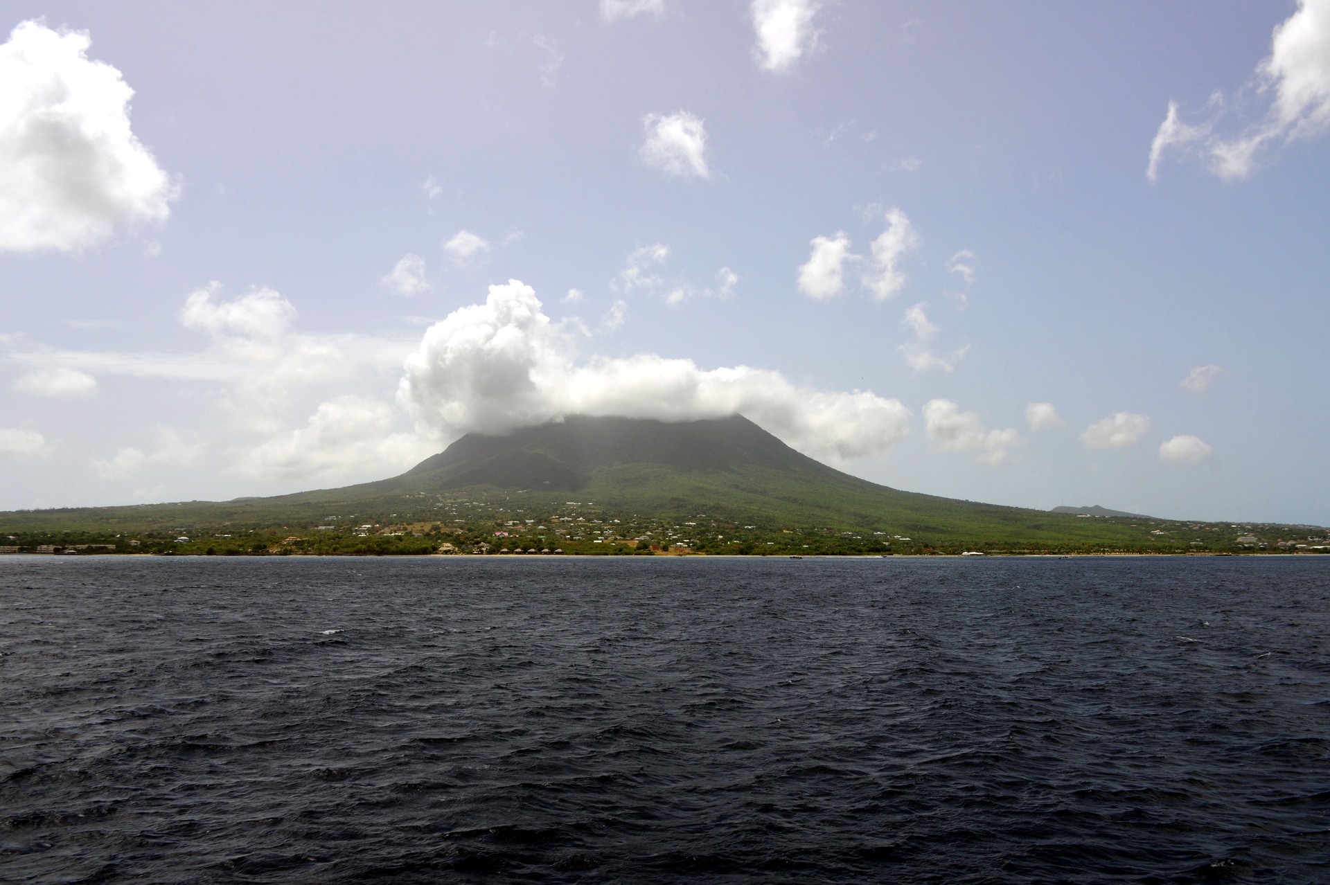 Nevis island, St Kitts and Nevis, Eastern Caribbean: the island with its volcano covered in tropical forest - view from the sea, 'The Narrows' strait, between Nevis and the island of St Kitts